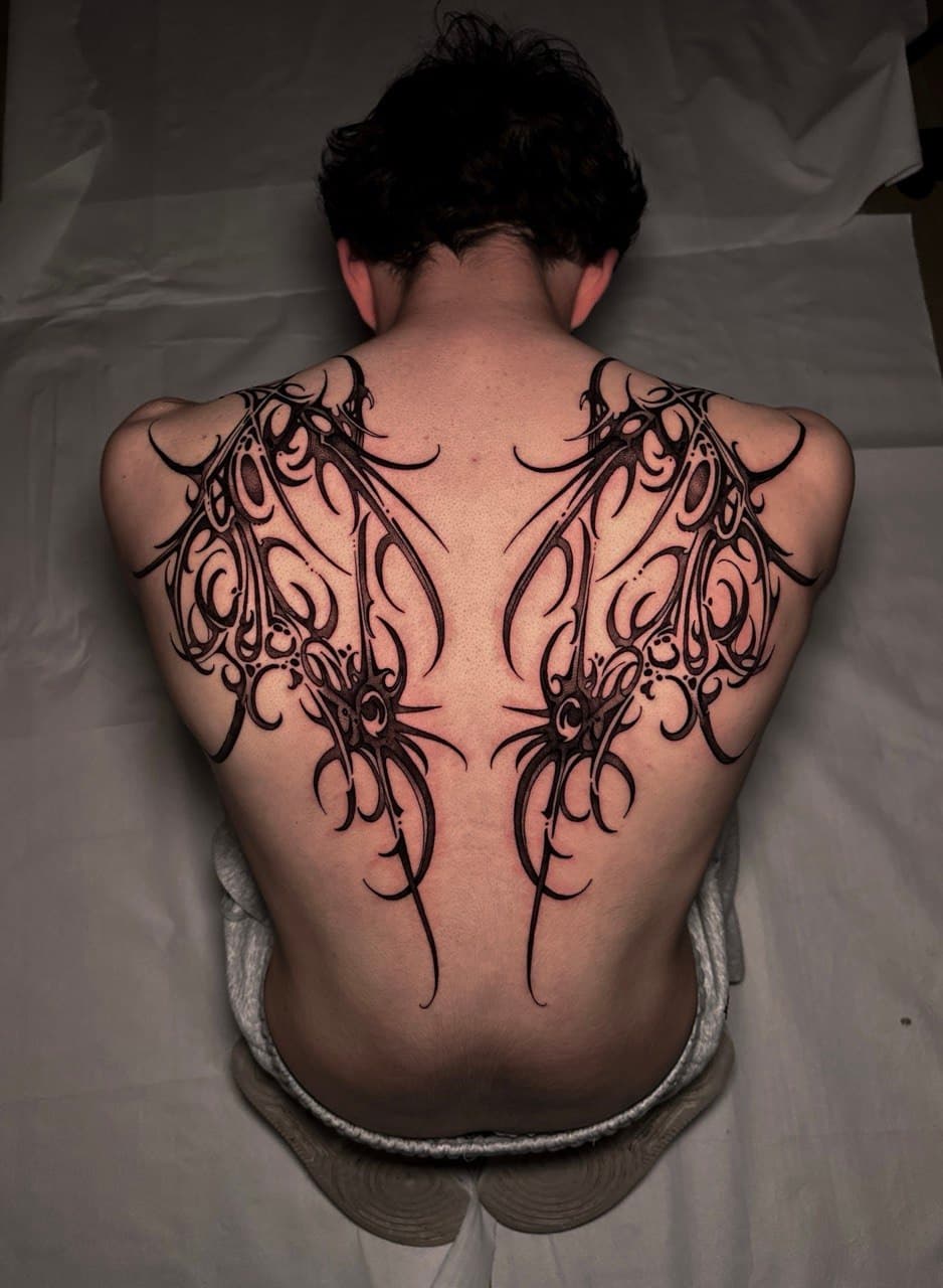 Tatuaggio schiena ali cybersigilism e lame biomeccaniche simmetriche Babydrop