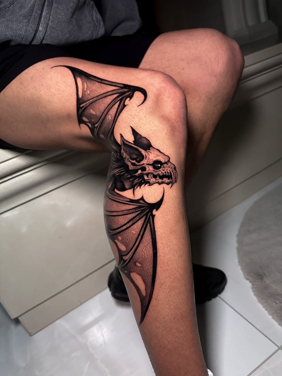 Tatuaggio anatomico pipistrello blackwork su gamba e ginocchio Babydrop