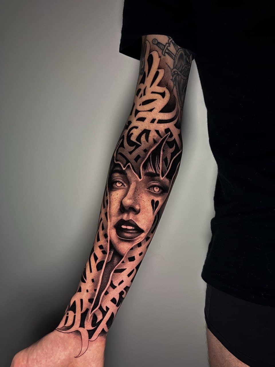 Tatuaggio volto demoniaco in spazio negativo tra lettere calligraffiti Babydrop