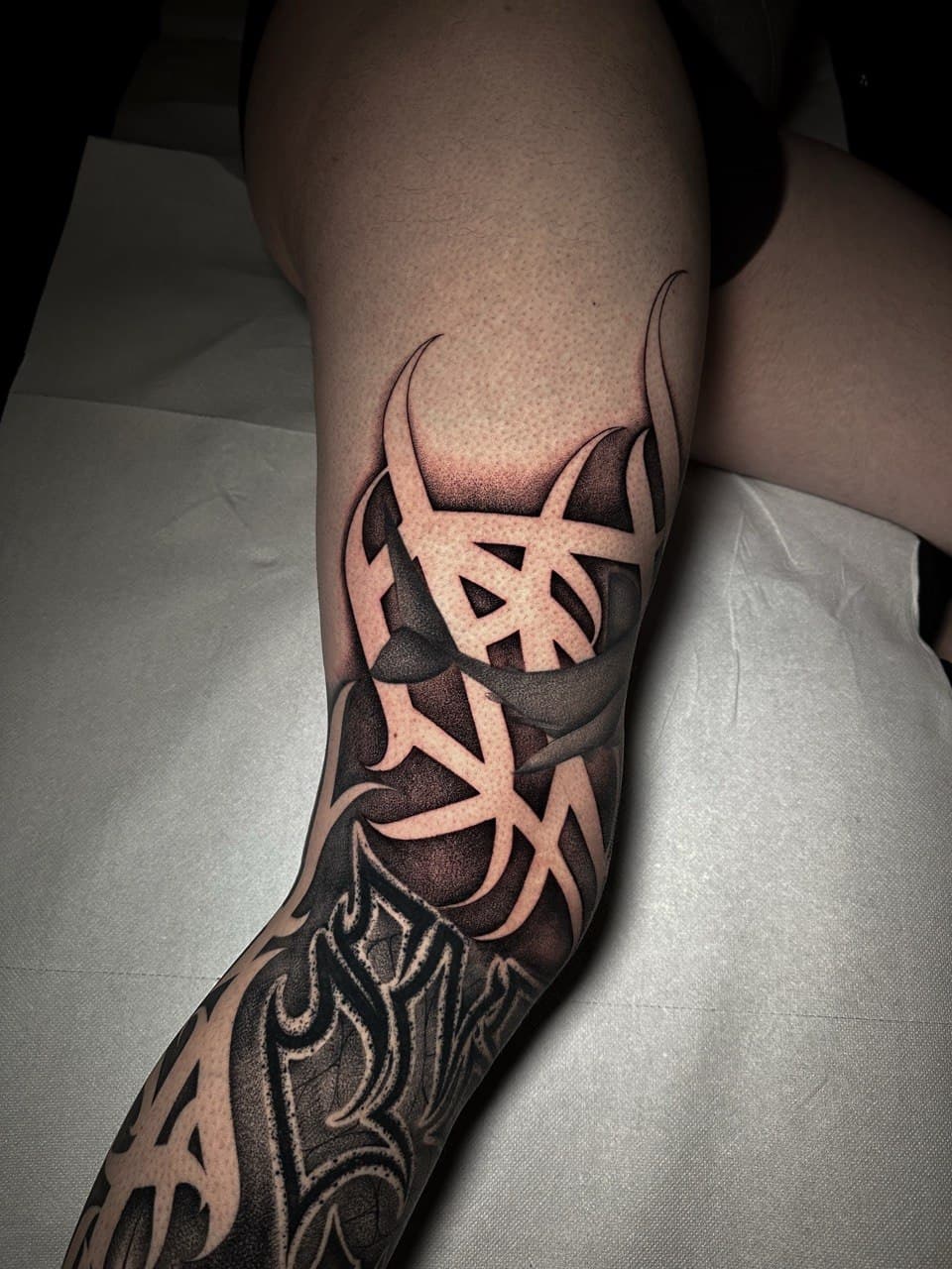 Tatuaggio blastover calligrafico in negativo su campitura dotwork Babydrop
